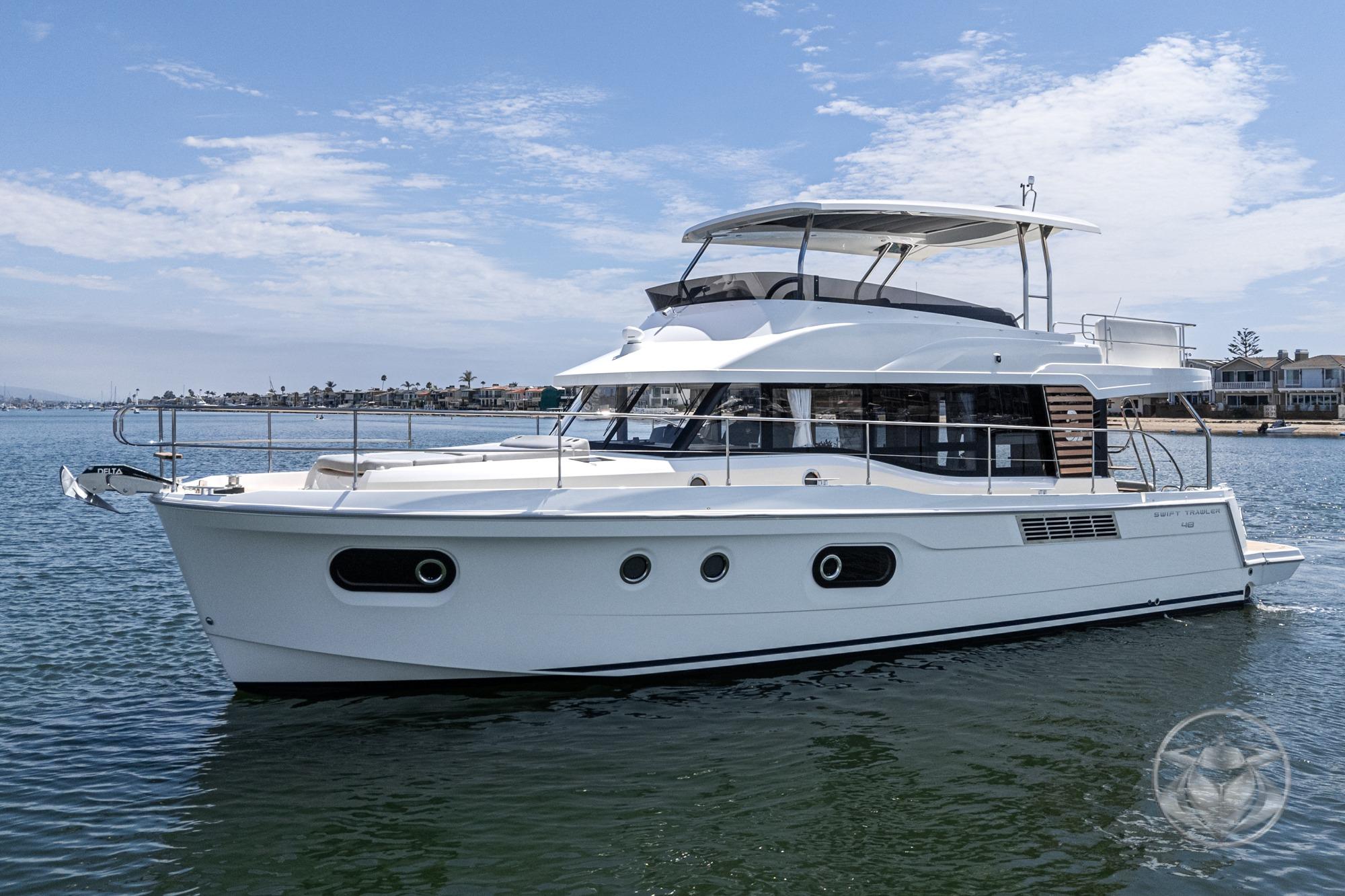 Beneteau Swift Trawler 48 2026 Beneteau Swift Trawler 48 cruising on calm waters under a clear sky.