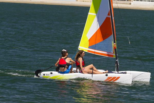 Hobie Cat Wave 2023 Hobie Cat Wave sailboat with two people sailing on a sunny day.