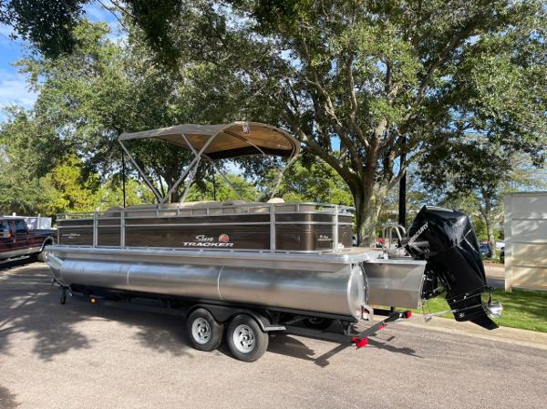 Sun Tracker Sportfish 24 XP3 2025 Sun Tracker Sportfish 24 XP3 pontoon boat on trailer, parked under trees.