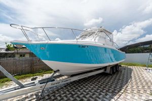 Pro-Line 35 Express 2007 Pro-Line 35 Express boat on trailer, blue and white, parked on checkered pavement.