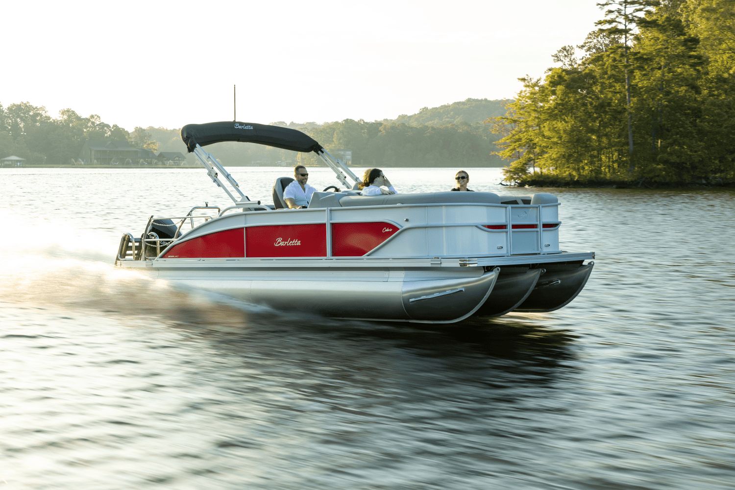 Barletta CABRIO 22 UC 2026 Barletta CABRIO 22 UC pontoon boat cruising on a serene lake.