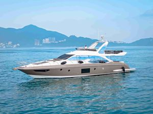 Azimut 66 Luxurious 2017 Azimut 66 yacht cruising on serene waters with scenic mountain backdrop.