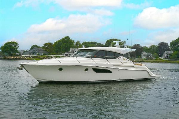 Tiara Yachts C44 Coupe 2015 Tiara Yachts C44 Coupe on calm water, surrounded by trees and houses.