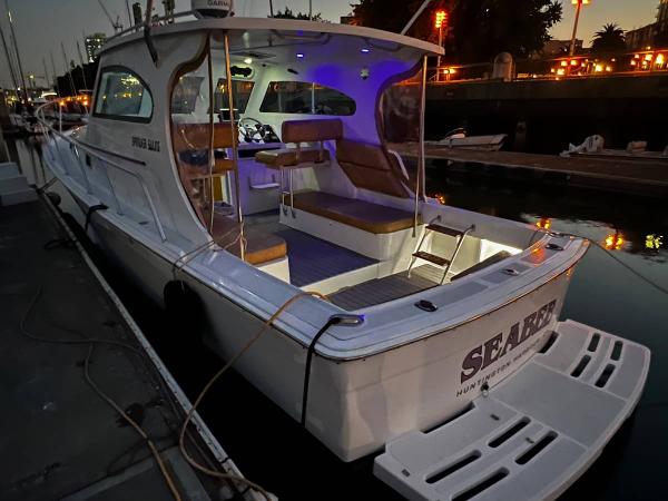 Mainship Pilot 30 1999 Mainship Pilot 30 boat docked at night with illuminated interior.
