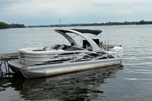Bennington R 23 Swingback 2021 Bennington R 23 Swingback pontoon boat docked on a calm lake.