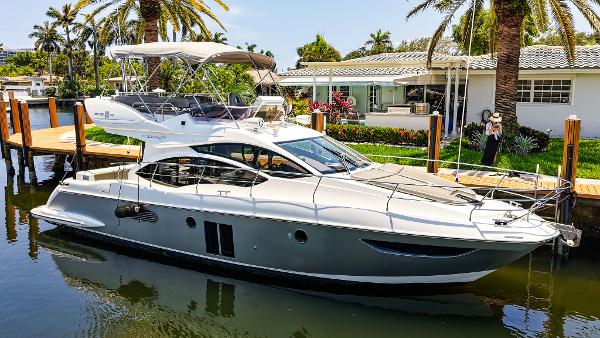 Azimut 42 Fly Azimut 42 Fly 2017 yacht docked by a waterfront home with palm trees.
