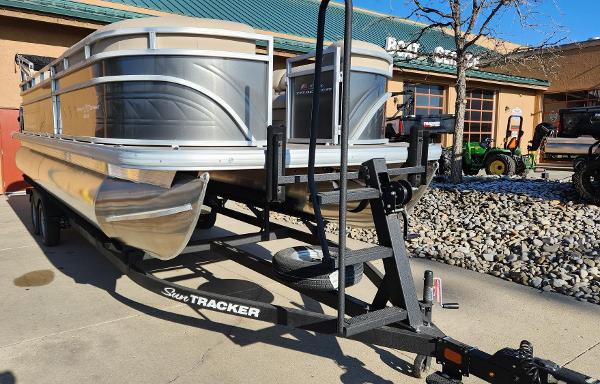 Sun Tracker Party Barge 22 DLX 2025 Sun Tracker Party Barge 22 DLX pontoon boat on trailer, parked outdoors.