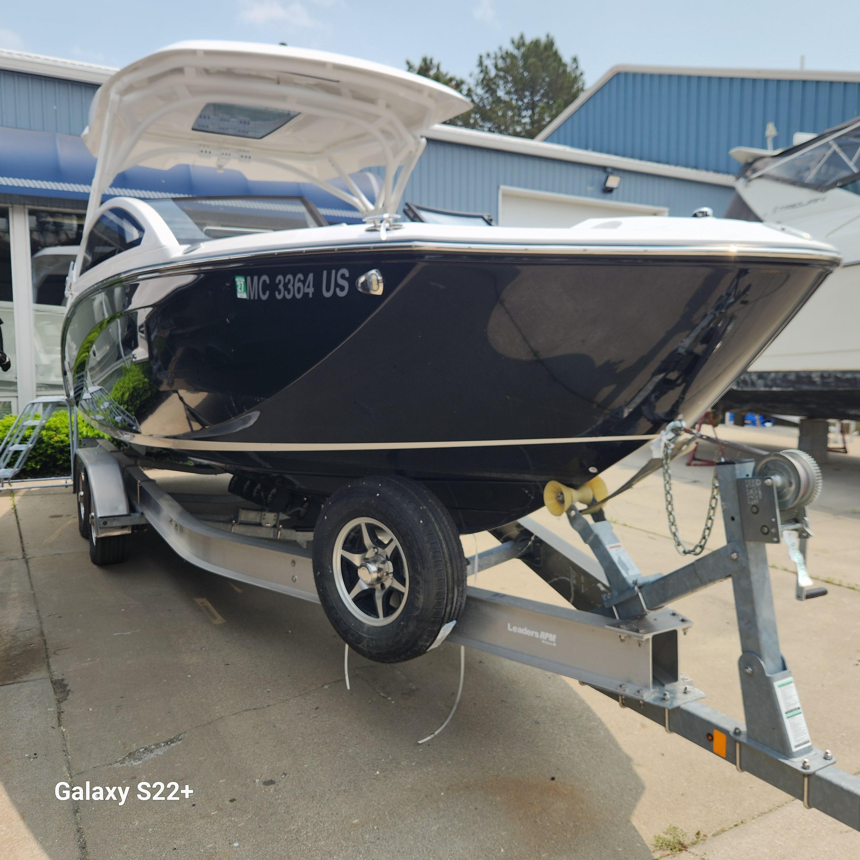 Yamaha Boats 275 SD 2022 Yamaha Boats 275 SD on trailer, parked outdoors near blue building.