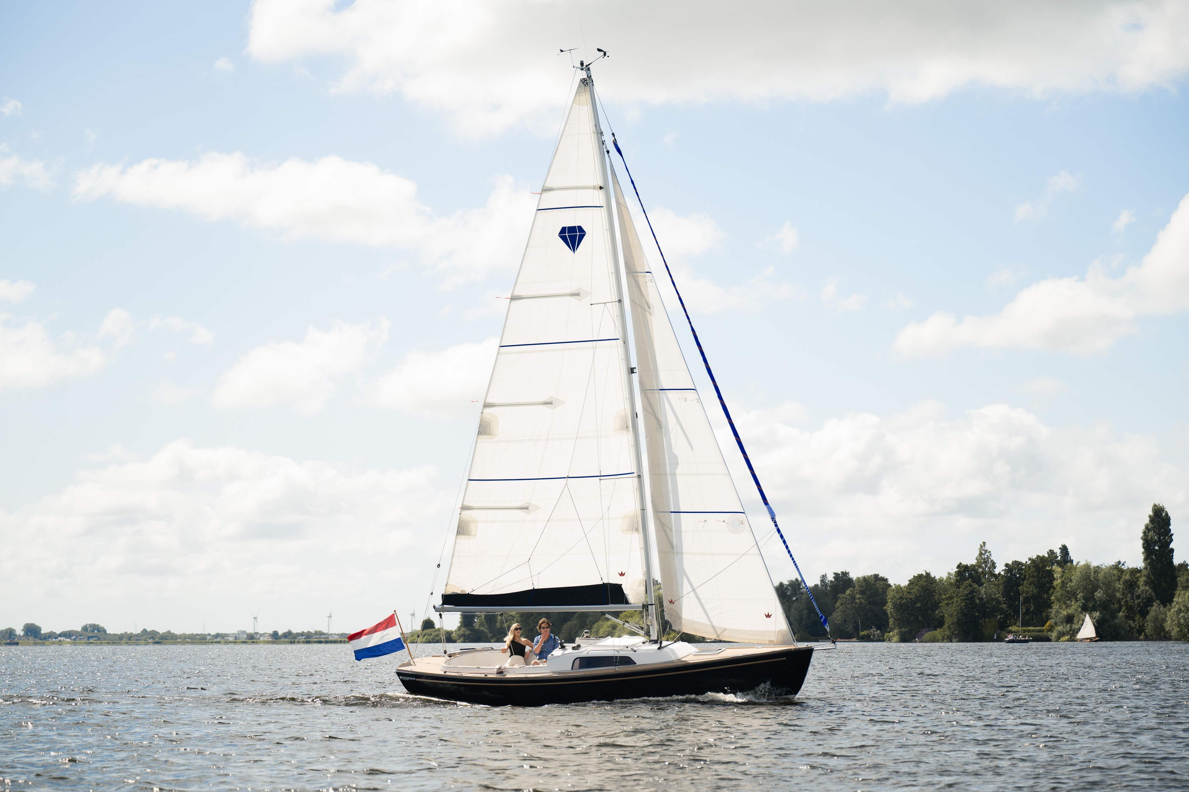 Saffier SC 8M Cabin Saffier SC 8M Cabin 2026 sailing on a serene lake under a partly cloudy sky.