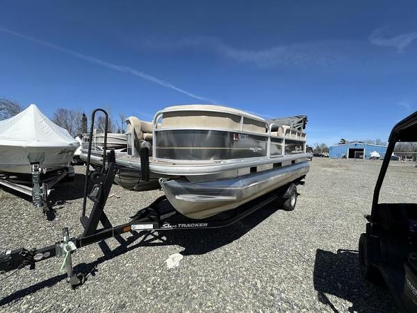 Sun Tracker Party Barge 18 DLX 2021 Sun Tracker PARTY BARGE® 18 DLX pontoon boat on trailer in outdoor setting.