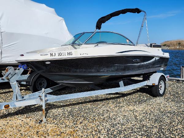 Sea Ray 175 Sport 2010 Sea Ray 175 Sport boat on trailer, parked on gravel near water.