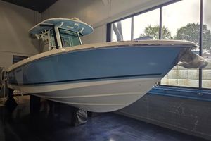 Boston Whaler 280 Outrage 2026 Boston Whaler 280 Outrage boat in showroom, featuring sleek blue hull design.