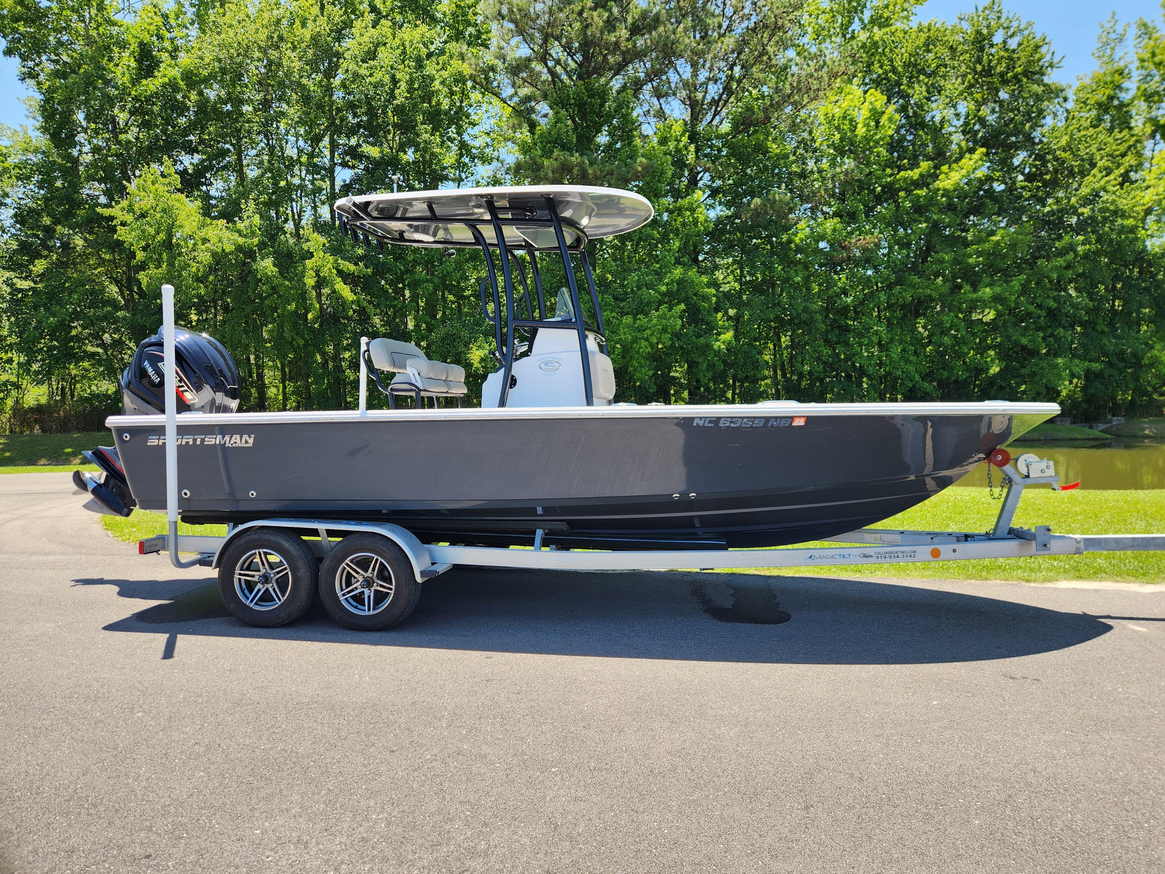 Sportsman Masters 227 Bay Boat 2023 Sportsman Masters 227 Bay Boat on trailer, parked outdoors with lush green background.