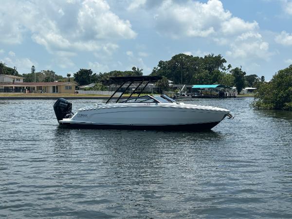 Cobalt R8 Outboard 2024 Cobalt R8 Outboard boat on calm water with houses in the background.