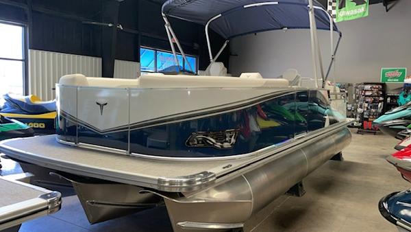 Tahoe LTZ 2385 QLS 2025 Tahoe LTZ 2385 QLS pontoon boat in showroom, featuring sleek design and canopy.