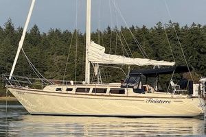 S2 11.0 1979 S2 11.0 sailboat on calm water, forested background, named "Finisterre."