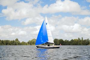 Saffier SC 6.5 Cruise 2026 Saffier SC 6.5 Cruise sailboat with blue sail on a serene lake.