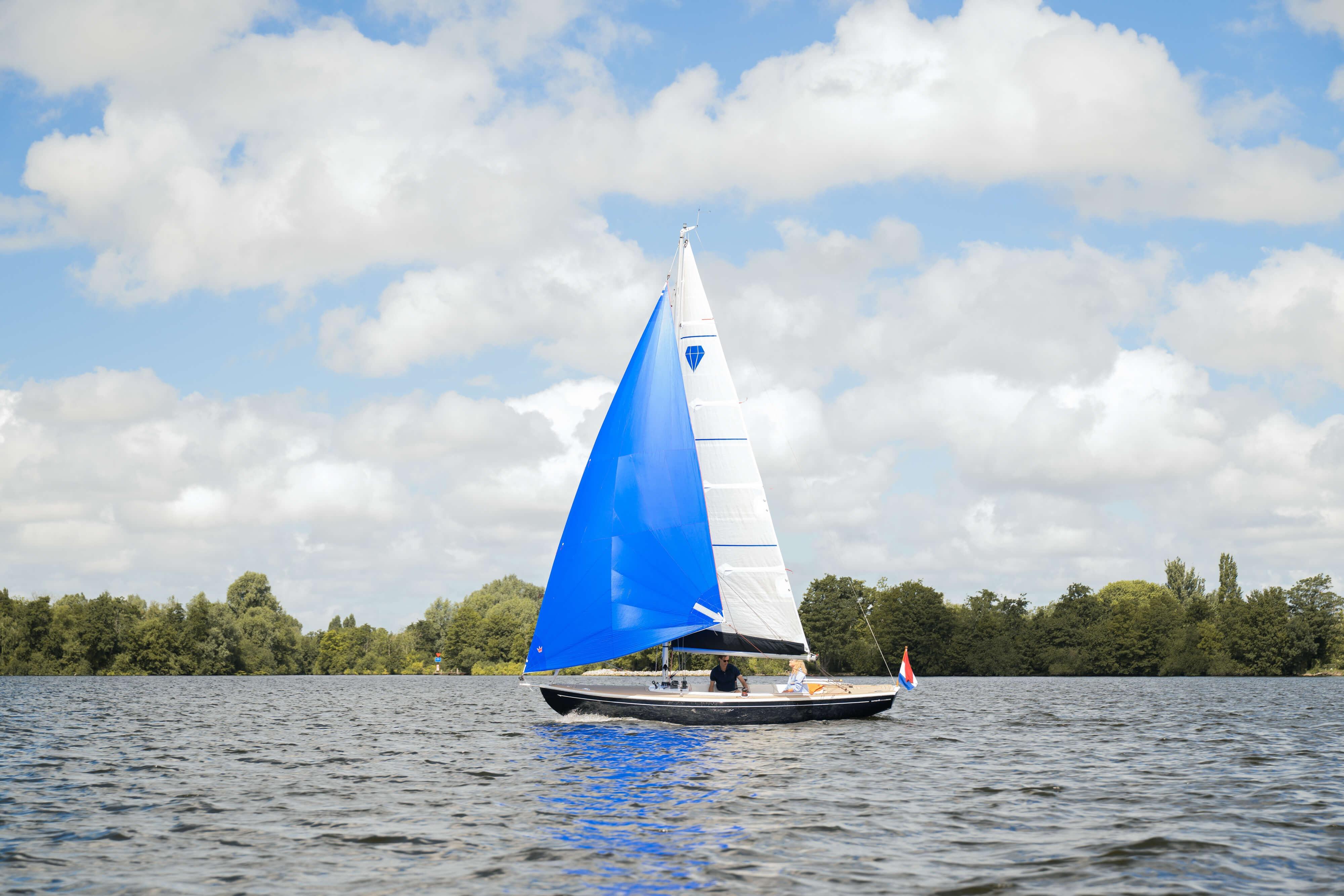 Saffier SC 6.5 Cruise 2026 Saffier SC 6.5 Cruise sailboat with blue sail on a serene lake.