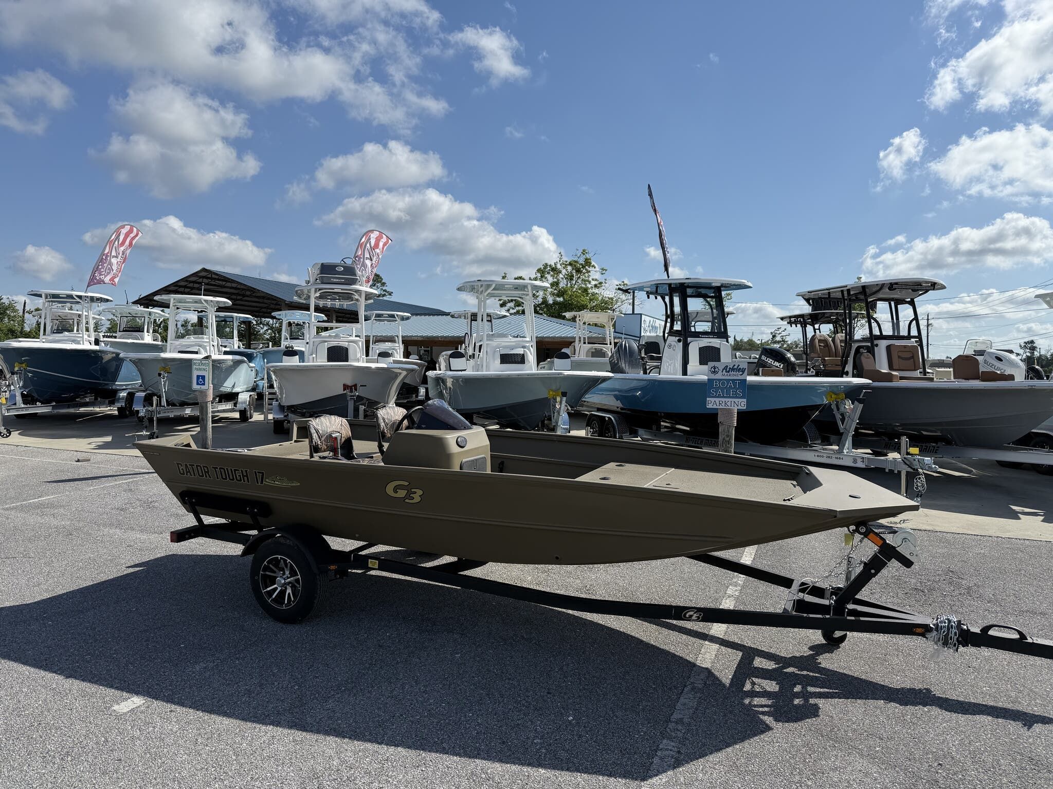 G3 Gator Tough 17 SC 2025 G3 Gator Tough 17 SC boat on trailer at dealership, clear sky background.