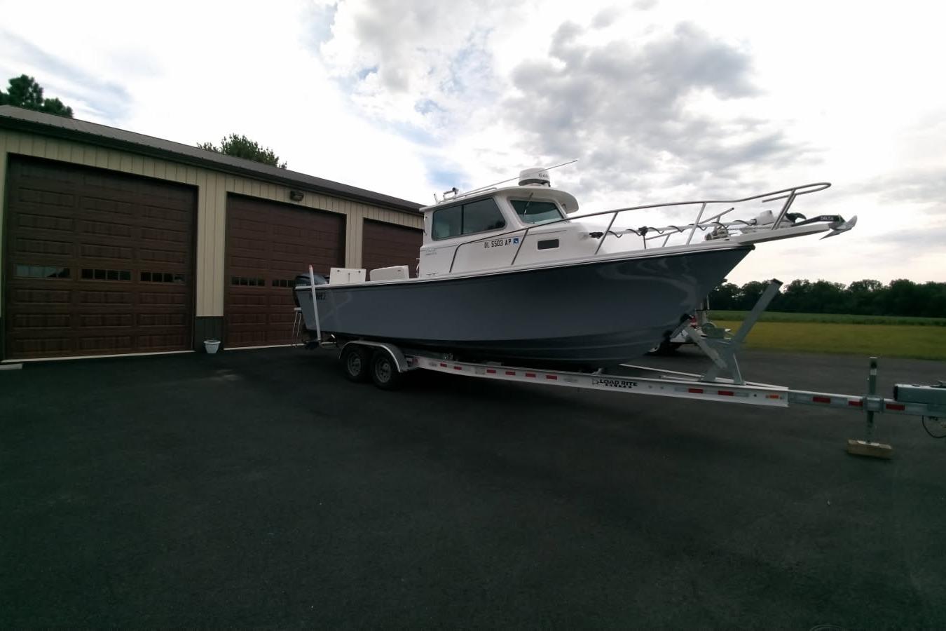 Parker 2820 XLD Sport Cabin 2024 Parker 2820 XLD Sport Cabin boat on trailer near garage.