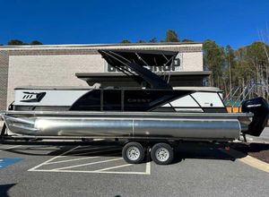 Crest Caribbean Platinum 250 SLC 2024 Crest Caribbean Platinum 250 SLC pontoon boat on trailer, parked outdoors.