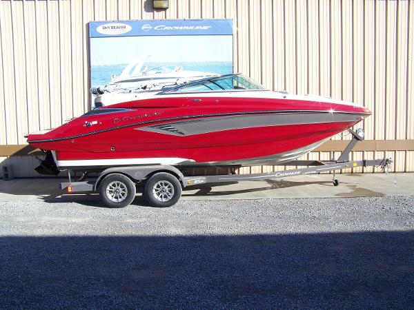 Crownline E235 2024 Crownline E235 red boat on trailer outside a building.