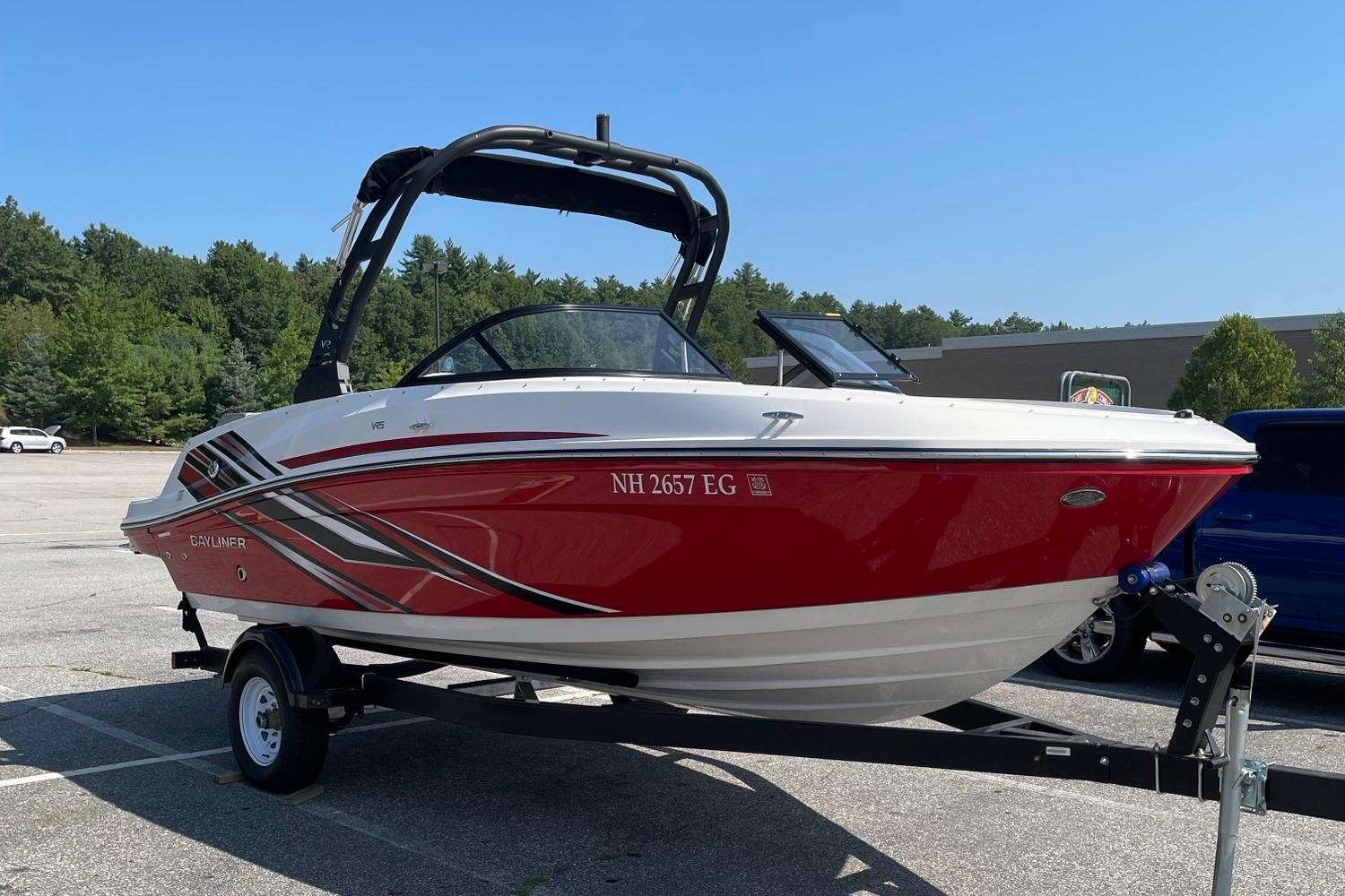 Bayliner VR5 Bowrider I/O 2024 Bayliner VR5 Bowrider I/O in red and white on a trailer, parked outdoors.