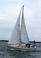 O'Day 28 1979 O'Day 28 sailboat navigating on open water under cloudy skies.