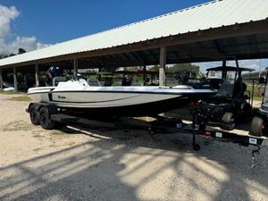 iKon VLX21 2025 iKon VLX21 boat on trailer under a metal roof, parked on gravel.