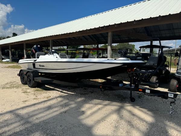 iKon VLX21 2025 iKon VLX21 boat on trailer under a metal roof, parked on gravel.