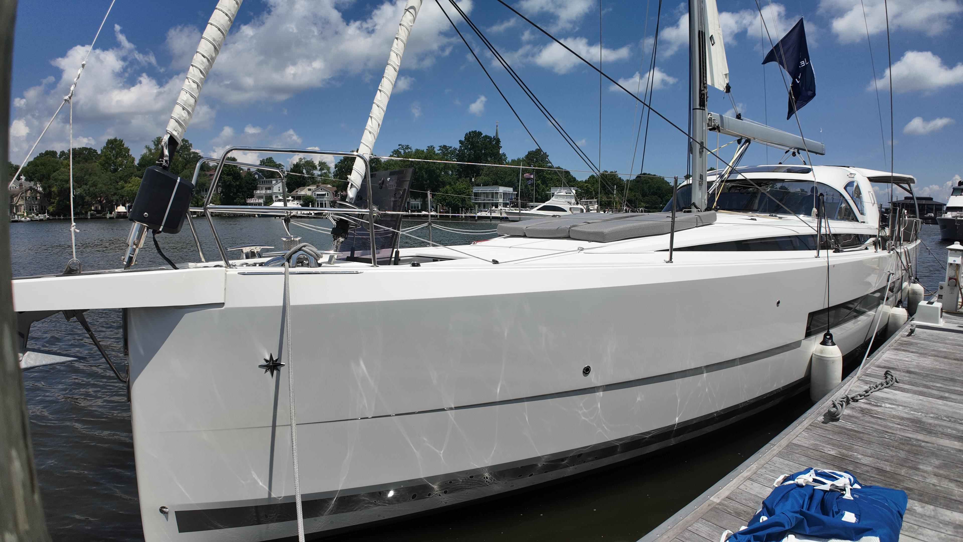 Jeanneau 55 2024 Jeanneau 55 yacht docked, showcasing sleek design and modern features under a clear blue sky.