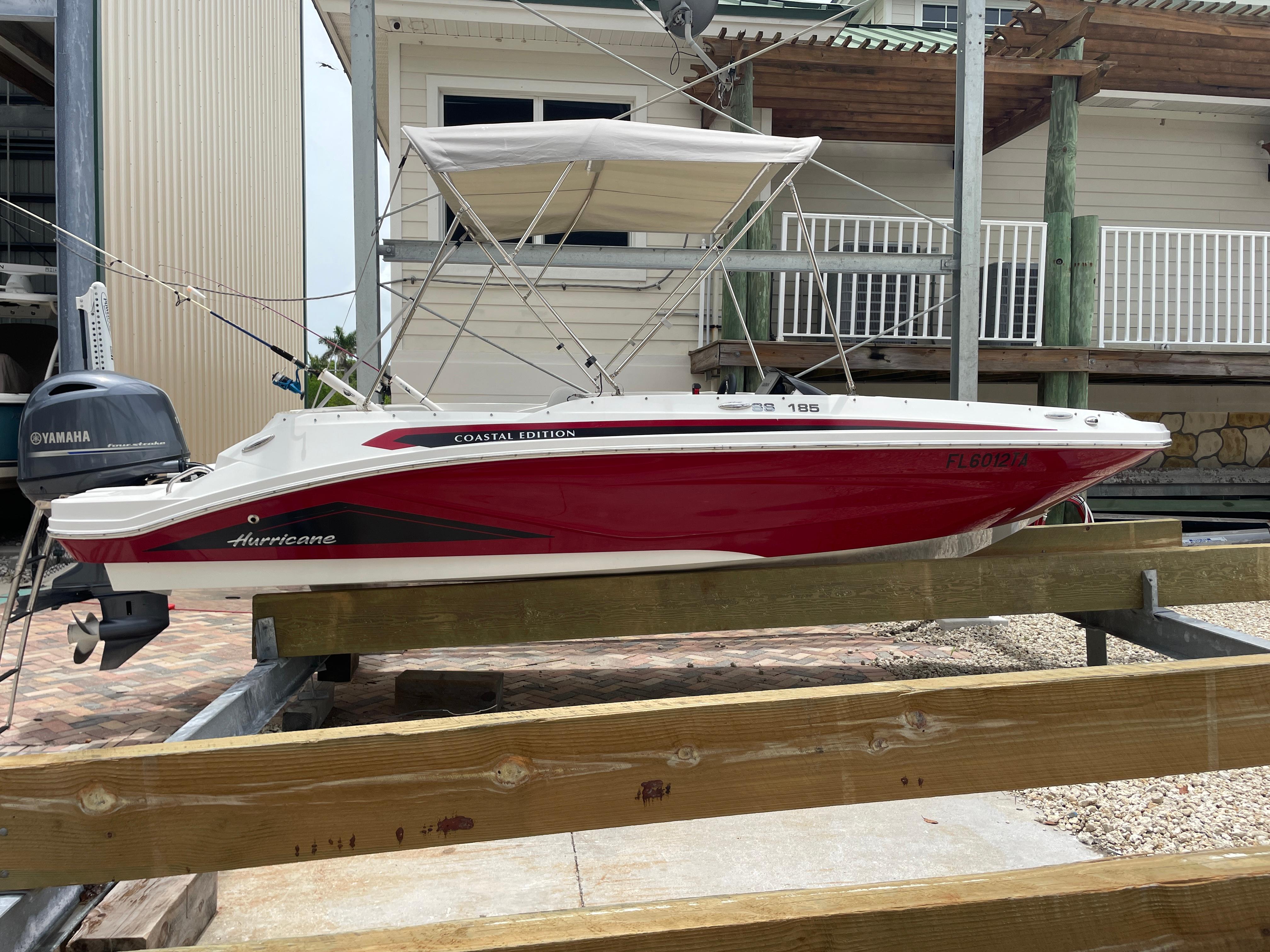Hurricane SunDeck Sport 185 OB 2021 Hurricane SunDeck Sport 185 OB boat with Yamaha engine, docked on wooden supports.