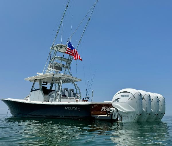 Regulator 41 2019 Regulator 41 boat with four Yamaha engines, American flag, calm sea.
