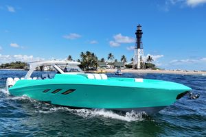Deep Impact 499 Sport Turquoise 2027 Deep Impact boat cruising near a lighthouse and palm trees.