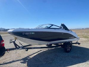 Scarab 195 ID 2022 Scarab 195 ID boat on trailer, parked outdoors under clear blue sky.