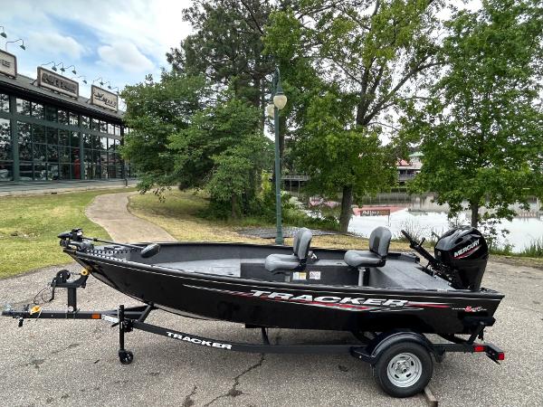 Tracker Super Guide V-16 T 2025 Tracker Super Guide V-16 T boat on trailer, parked near a lake and trees.