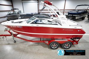 Four Winns H210 2020 Four Winns H210 red boat on trailer in indoor showroom.