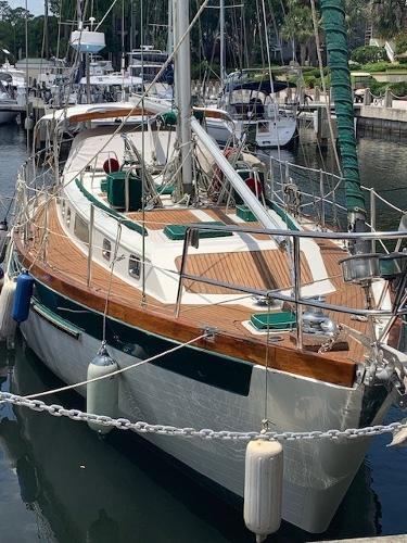 Slocum 43 1988 Slocum 43 sailboat docked in marina, featuring wooden deck and green accents.