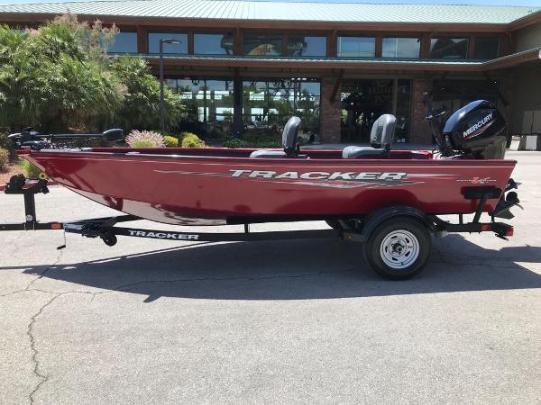 Tracker Super Guide V-16 T 2025 Tracker Super Guide V-16 T boat, red, parked outdoors with Mercury engine.
