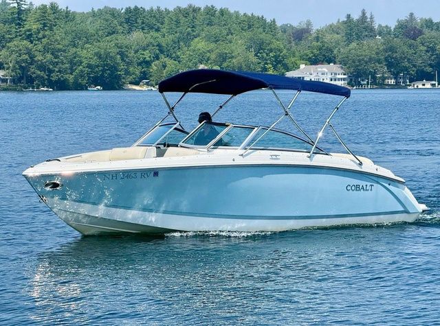 Cobalt R3 2015 Cobalt R3 boat cruising on a lake with a blue canopy.