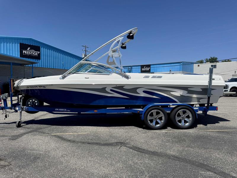 Custom B52 23 2006 Custom B52 23 boat on trailer, blue and white design, parked outside Prestige dealership.