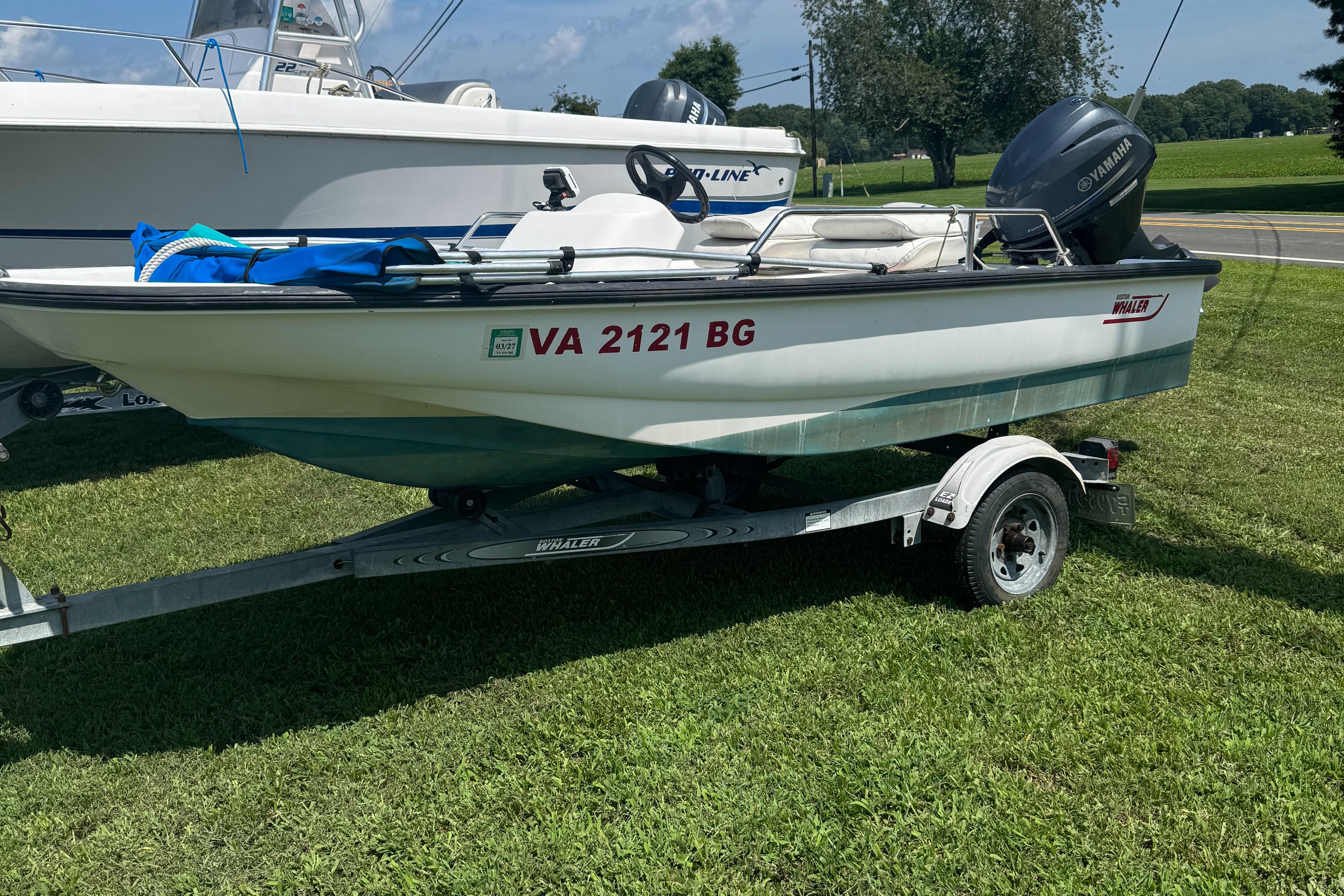 Boston Whaler Sport 13 2000 Boston Whaler Sport 13 boat on trailer, parked on grass.