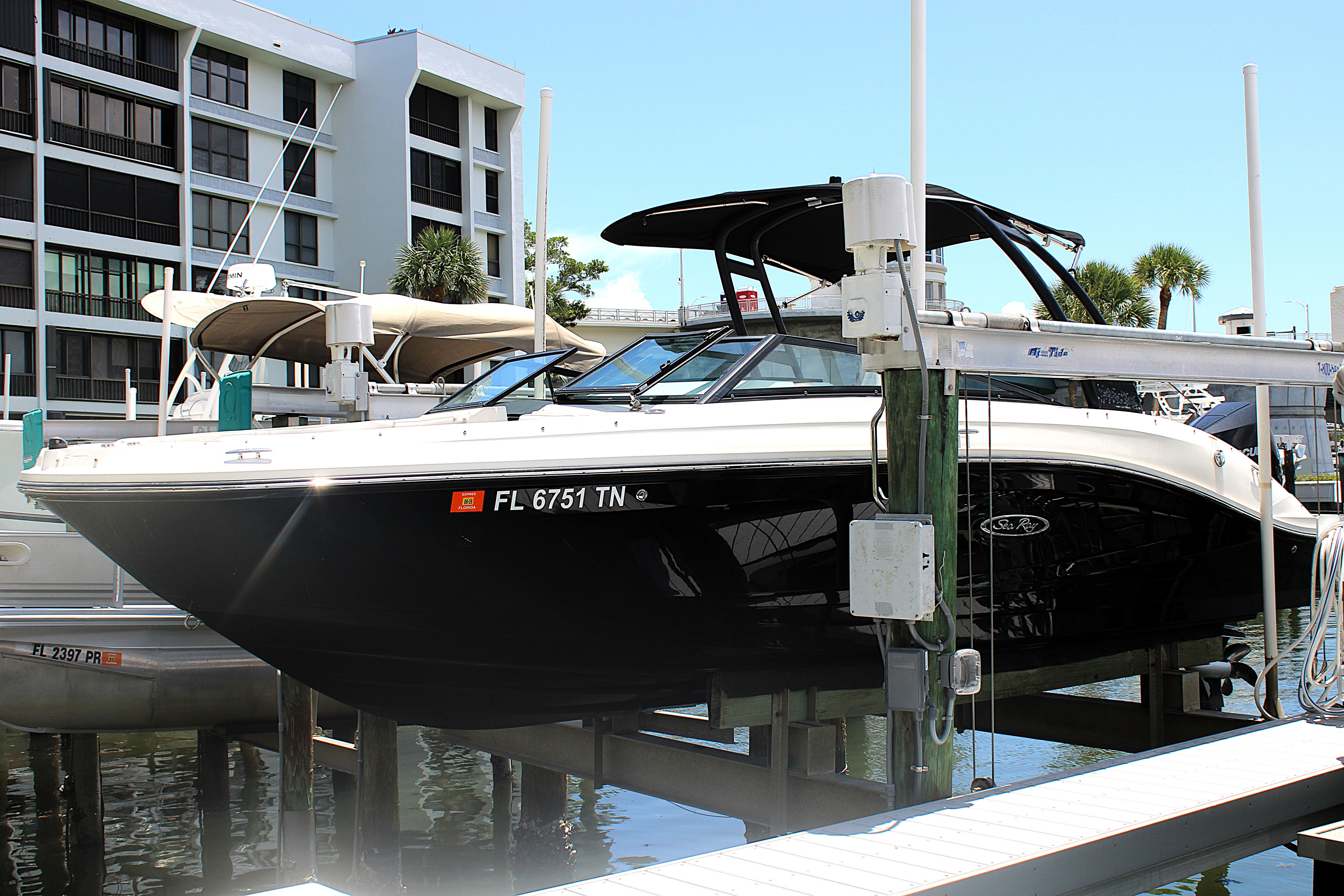 Sea Ray SPX 230 Outboard 2023 Sea Ray SPX 230 Outboard boat docked at marina, black hull, modern design.