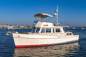 Grand Banks 42 Classic 1984 Grand Banks 42 Classic yacht on calm water, featuring a white hull and blue sky backdrop.
