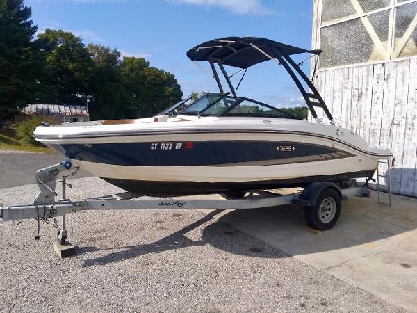 Sea Ray SPX 190 2017 Sea Ray SPX 190 boat on trailer, parked outdoors near a wooden building.