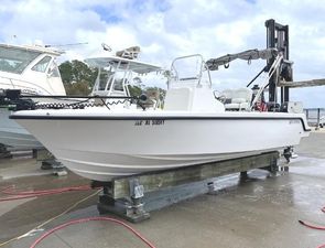 Reef Runner 230 XO 2024 Reef Runner 230 XO boat on dock, white hull, clear sky background.