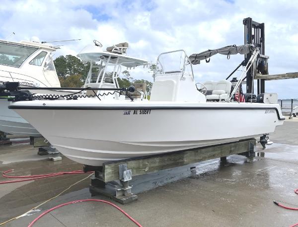 Reef Runner 230 XO 2024 Reef Runner 230 XO boat on dock, white hull, clear sky background.