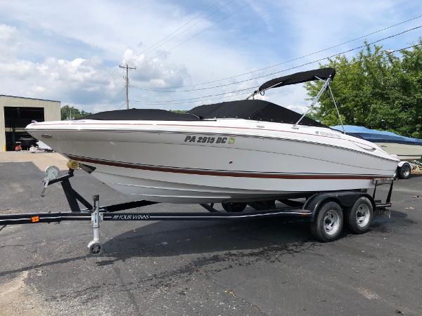 Four Winns H220 2010 Four Winns H220 boat on a trailer in a parking lot.