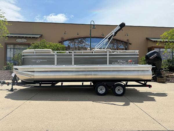 Sun Tracker Party Barge 22 RF DLX 2025 Sun Tracker Party Barge 22 RF DLX pontoon boat on trailer.