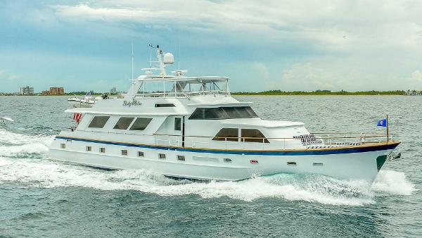 Broward 87 Luxury 1982 Broward 87 yacht cruising on open water under a cloudy sky.